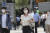 지난 4일 마스크를 쓴 도쿄 시민이 부채질을 하며 걸어가고 있다. [AP=연합뉴스]