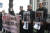 강제동원 피해자 유족인 이규매(오른쪽 첫번째), 박재훈 씨(두번째)가 2019년 2월 15일 피해자의 사진을 들고 일본 도쿄 마루노우치에 있는 미쓰비시(三菱) 중공업 본사 앞에서 지원단체 관계자와 함께 서 있다. [연합뉴스]