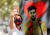 한 여성팬이 혁명가 체 게바라를 모티브로 그린 메시 벽화 앞에서 마스크를 쓴 채 기념 셀카 사진을 찍고 있다. [로이터=연합뉴스]