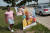 1일(현지시간) 코로나19로 사망한 희생자의 유가족이 디트로이트 벨섬에 전시된 희생자들의 사진 옆에 나란히 서고 있다. 유가족의 모습이 사진 속 희생자와 많이 닮았다. 로이터=연합뉴스