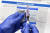 미국 국립보건원(NIH)과 바이오 기업인 모데나가 공동으로 개발한 코로나19 백신을 한 간호사가 손에 들고 보여주고 있다. AP=연합뉴스 