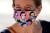  23일(현지시간) 루스 베이더 긴즈버그 미 연방대법관의 얼굴이 그려진 마스크를 쓰고 온 여성이 조문을 하기 위해 대법원을 찾았다.[AFP=연합뉴스]