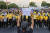 14일 왕실 지지자들이 노란색 티셔츠를 입고 맞불 집회를 벌이고 있다. 그 앞에선 민주화 시위 참가자가 왕실을 비판하는 글을 적은 종이를 들고 있다. [AFP=연합뉴스] 