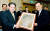 2003년 10월 이건희 삼성 회장(왼쪽)이 당시 황창규 삼성전자 사장(오른쪽)으로부터 삼성이 세계 최초로 개발에 성공한 70나노 4기가 낸드(NAND)플래시 메모리 개발 기념패를 받고 있다. 사진 중앙포토