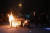 27일(현지시간) 펜실베이니아주 필라델피아에서 시위대가 불이 붙은 바리케이드 옆에 서 있다. [연합뉴스]