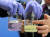 지난 7월 30일 서울시청에서 열린 가짜석유 적발 브리핑에서 관계자들이 시약으로 판별한 가짜 경유와 진짜 경유를 비교하고 있다. 연합뉴스