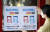 지난 12일 오전 광주 북구의 한 커피숍에서 광주 북구보건소 감염병관리팀 직원이 마스크 착용 의무화 시행으로 13일부터 미착용 시 과태료를 부과한다는 안내문을 붙이고 있다. 연합뉴스
