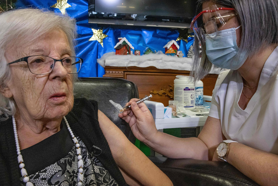 14일(현지시간) 89세인 지젤 레베크 할머니가 캐나다에서 첫 번째로 화이자 백신을 접종받고 있다. [EPA=연합뉴스]