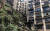 중국 충칭의 난안구에서 발견된 대형 석각은 높이 9m 정도로 머리 부분으로 9층 아파트 건물을 이고 있다. [중국 텅쉰망 캡처]