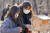  심여진(왼쪽) 학생기자가 도봉숲속마을 사무국 김보경 인턴과 함께 준비한 새 먹이를 먹이대에 놓고 있다. 