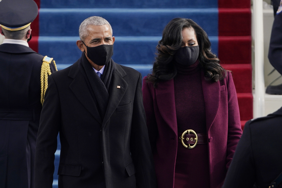 20일(현지시간) 취임식장에 44대 오바마 전 대통령과 부인 미셸 오바마 여사가 손을잡고 입장하고 있다. AP=연합뉴스