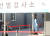 코로나19 확진자가 국내에서 처음 발생한 지 1년째가 되는 20일 서울광장에 마련된 선별 진료소에서 의료진이 기둥에 기대 휴식을 취하고 있다. 중앙포토