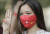 6일 미얀마 양곤에서 열린 쿠데타 반대 시위에 참가한 시민이 아웅산 수치 국가고문이 이끄는 정당인 민주주의민족동맹(NLD) 당기가 그려진 얼굴 마스크를 쓰고 저항의 상징 ‘세 손가락’ 경례를 하고 있다. [사진 EPA=연합뉴스]