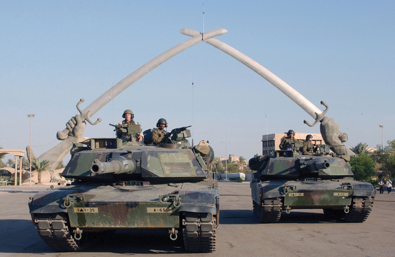 2003년 11월 13일 미국 육군의 M1 에이브럼스 탱크가 이라크의 수도 바그다드의 개선문인 '승리의 손'을 지나치고 있다. 미국은 그해 3월 20일 이라크를 침공한 뒤 4월 9일 바그다드를 점령했다. 개전 20일 만이다.  [미 국방부]