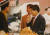 1996년 3월 노점에서 음식을 시식하며 상인의 이야기를 듣는 노무현 민주당 후보(오른쪽)와 이광재 당시 노무현 비서(왼쪽) 출처=노무현 사료관