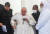이라크를 방문 중인 프란치스코 교황이 3월 6일 아브라함의 탄생지로 알려진 우르의 유적지에서 종교간 대화를 한 뒤 일어서면서 수행 사제들의 부축을 받고 있다. 로이터=연합뉴스 