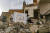 이라크 북부 모술의 시리아 가톨릭 교회 소속 성모마리아 교회의 폐허 앞에서 신자들이 지난 3월 2일 교황을 환영하는 현수막을 달고 있다. AFP=연합뉴스 
