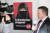 7일(현지시간) 발토 보프만 스위스 국민당 의원이 ‘극단주의 그만’이라고 쓴 캠페인 포스터를 배경으로 방송 인터뷰를 하고 있다. [EPA=연합뉴스]