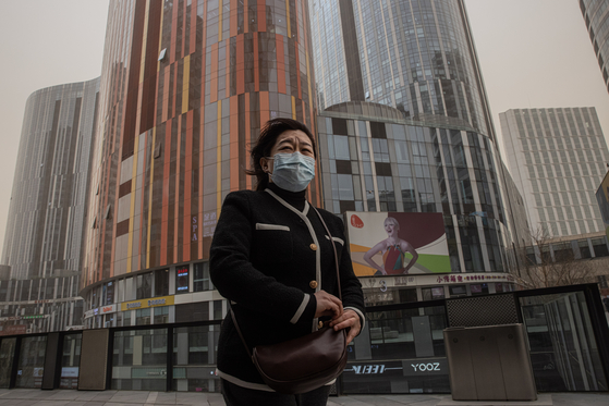 중국에 심한 황사가 불어닥친 지난 15일 마스크를 착용한 여성이 베이징 시내를 걷고 있다. EPA=연합뉴스