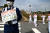 전 일본여자축구대표팀 선수들이 성화 봉송에 나선 가운데 한 경찰이 코로나19 예방 협조 표지판을 목에 걸고 있다. [신화통신=연합뉴스]