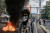 시위대 중 청년 한 명이 복면을 하고 불타는 바리케이드 근처에 서있다. 30일 양곤의 모습이다. AFP=연합뉴스