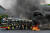 3일(현지시간) 미얀마 양곤 지역의 버스가 화염에 휩싸인 거리를 지나고 있다.[AFP=연합뉴스]