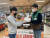 GS수퍼마켓에서 직원이 배송을 맡은 ‘우리동네딜리버리친구’에게 배달 상품을 전달하고 있다. [사진 각 사]