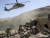 2009년 8월 19일 아프간 와르다크 주 전투현장. 미군 전투 차량이 폭발물에 의해 전복된 뒤 사상자가 다수 발생한 현장에 병원 헬기가 착륙하고 있다. AP=연합뉴스
