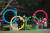 지난달 19일 일본 도쿄 올림픽 박물관에 설치된 오륜 조형물 인근에서 시민들이 사진을 찍고 있다. [AP=연합뉴스]