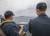 미 제7함대 소속 이지스함인 머스틴함 함장(왼쪽)이 두 발을 난간에 올린 채 필리핀 해역에서 훈련 중인 중국 항공모함 랴오닝함을 감시하고 있다. 오른쪽은 머스틴함 부함장. 랴오닝함은 일본 호위함 감시도 받았다. [사진 미 해군]