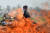 최근 인도에서 하루 코로나 확진자가 40만명을 넘기고 있는 가운데 지난 8일 인도에서 한 노동자가 코로나 사망자들의 시신을 화장하고 있는 모습. [AFP=연합뉴스]