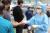 지난 18일 오후 대구 서구보건소 관계자가 선별진료소에서 코로나19 검사를 기다리는 외국인에게 비닐 장갑을 나눠주고 있다. 뉴스1