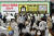 마스크를 쓴 시민들이 지난 28일 일본 도쿄 도심에 설치된 변이 바이러스 감염 주의 광고판 앞을 지나고 있다. [AP=연합뉴스]
