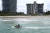 26일(현지시간) 미국 플로리다 마이애미 지역 바다에서 한 시민이 제트스키를 타며 이틀 전 무너진 챔플레인 아파트를 바라보고 있다.[AP=연합뉴스]