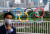 지난달 27일 일본 도쿄에서 마스크를 쓴 시민이 올림픽 조형물 앞을 지나고 있다. [로이터=연합뉴스]