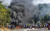 12일 남아프리카공화국 더반의 한 쇼핑센터 외곽에 바리케이드가 불타는 가운데 일부 시민이 물건을 약탈하고 있다. 경찰은 이날 제이콥 주마 전 대통령의 구금으로 발생한 소요가 격렬해지는 가운데 6명이 사망하고 200명 이상이 체포됐다고 밝혔다. AP=연합뉴스