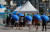 18일 서울 중구 서울역 광장에 마련된 신종 코로나바이러스 감염증(코로나19) 임시 선별검사소에서 시민들이 검사소에서 대여한 우산을 쓴 채 검사를 위해 차례를 기다리고 있다. 연합뉴스
