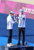양궁 혼성에서 금메달을 딴 김제덕(오른쪽)과 안산이 24일 시상대에 올라 서로 금메달을 걸어 주고 있다. [올림픽사진공동취재단]