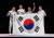 펜싱 남자 사브르 대표팀 구본길, 오상욱, 김정환, 김준호(왼쪽부터)가 단체전 금메달을 확정한 뒤 태극기를 들고 기뻐하는 모습 [올림픽사진공동취재단]