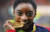 2016년 리우 올림픽 당시 미국 체조여왕 시몬 바일스가 여자 개인종합 금메달을 입에 물고 있다. [AP=연합뉴스]