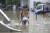 지난달 21일 중국 중부 허난성 정저우 시에서 기록적인 폭우로 홍수가 발생한 거리를 한 남성이 여성을 업고 지나고 있다. 허난성 당국은 이번 홍수로 300명 이상이 사망하고 최소 50명이 실종되었다고 발표했다. AP=연합뉴스