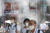 5일 일본 도쿄에서 마스크를 쓴 시민들이 도심 온도를 낮추기 위해 설치된 '미스트 샤워' 앞을 지나고 있다. [AP=연합뉴스]