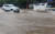 지난 18일 강원 강릉 시내에서 차량이 물에 잠긴 도로를 지나고 있다. 연합뉴스