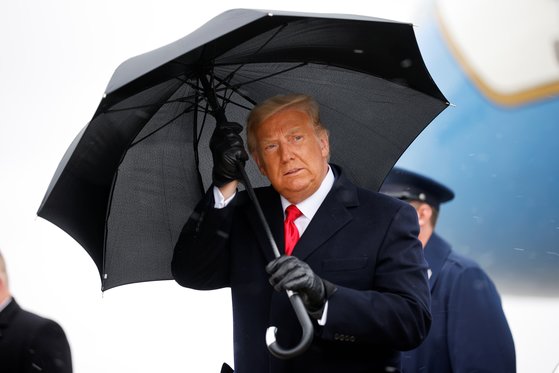 도널드 트럼프 전 미국 대통령이 지난해 공항에서 우산을 쓰고 이동하는 모습. 로이터=연합뉴스