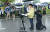 강성국 법무부 차관이 지난 27일 오후 충북혁신도시 국가공무원인재개발원 정문 앞에서 아프가니스탄 특별기여자 초기 정착 지원을 발표하는 브리핑을 하고 있다. 강 차관 뒤에서 한 공무원이 무릎을 꿇고 우산을 받쳐주고 있다. 뉴시스