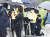 지난 27일 충북 국가공무원 인재개발원에서 열린 법무부 브리핑에서 강성국 차관(가운데)에게 무릎을 꿇고 우산을 씌워준 보좌진의 모습. [연합뉴스]