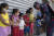 브라질 리우데자네이루주에서 슈퍼히어로 캡틴 아메리카로 분장한 군인이 아이들의 손에 소독제를 뿌려주고 있다. [AP=연합뉴스]