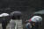 빗방울이 쏟아지는 가운데 시민들이 우산을 쓴 채 횡단보도를 건너고 있다. 연합뉴스