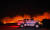 12일(현지시간) 산타 바바라 카운티의 101번 고속도로로 번진 산불을 등지고 소방차량이 이동하고 있다. AP=연합뉴스