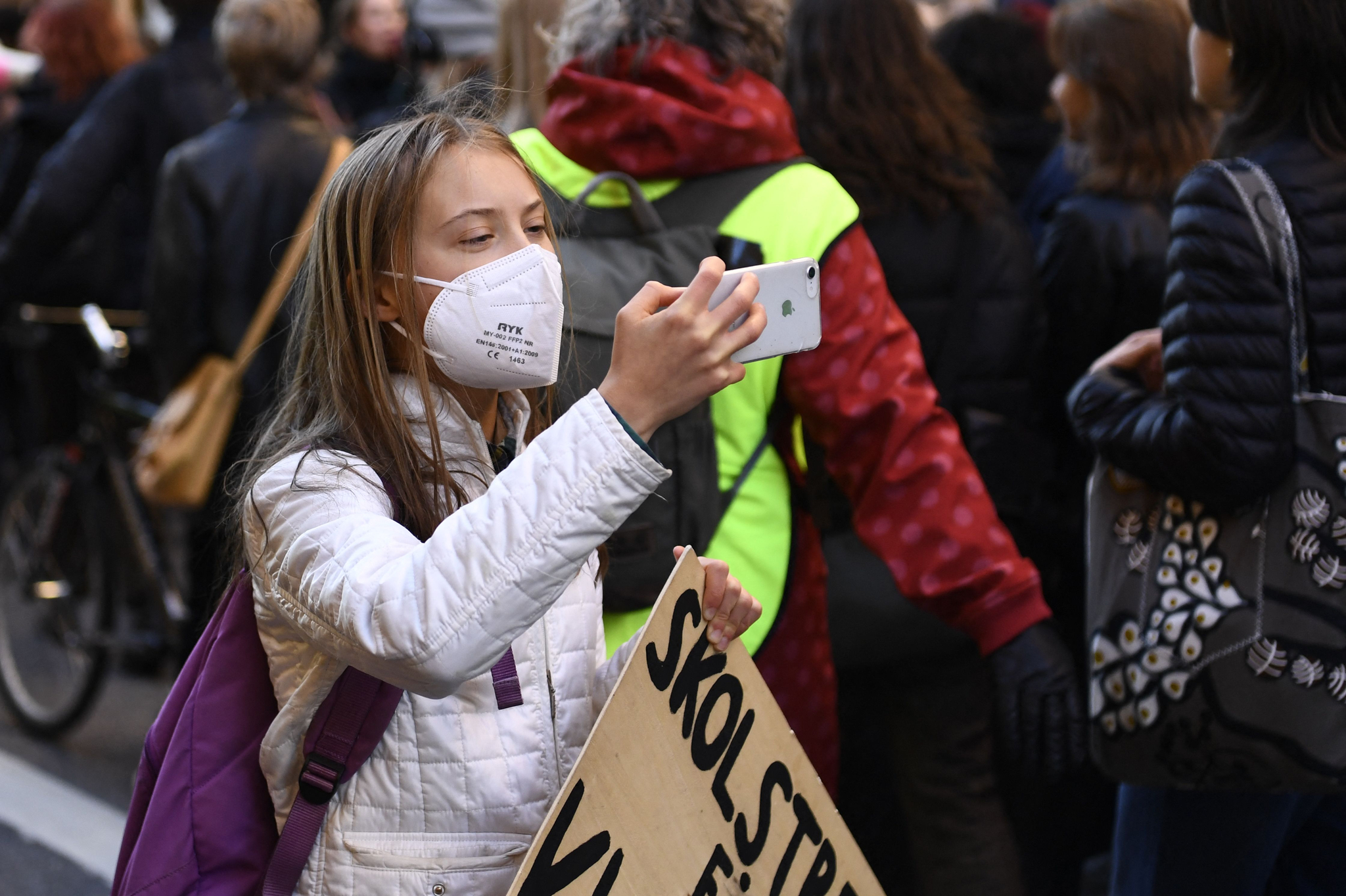 스웨덴의 기후 활동가 그레타 툰베리가 22일(현지시간) 스웨덴 스톡홀름에서 열린 기후 파업 시위 도중 손에 '기후 파업' 피켓을 든 채 휴대전화로 뭔가를 촬영하고 있다. AFP=연합뉴스